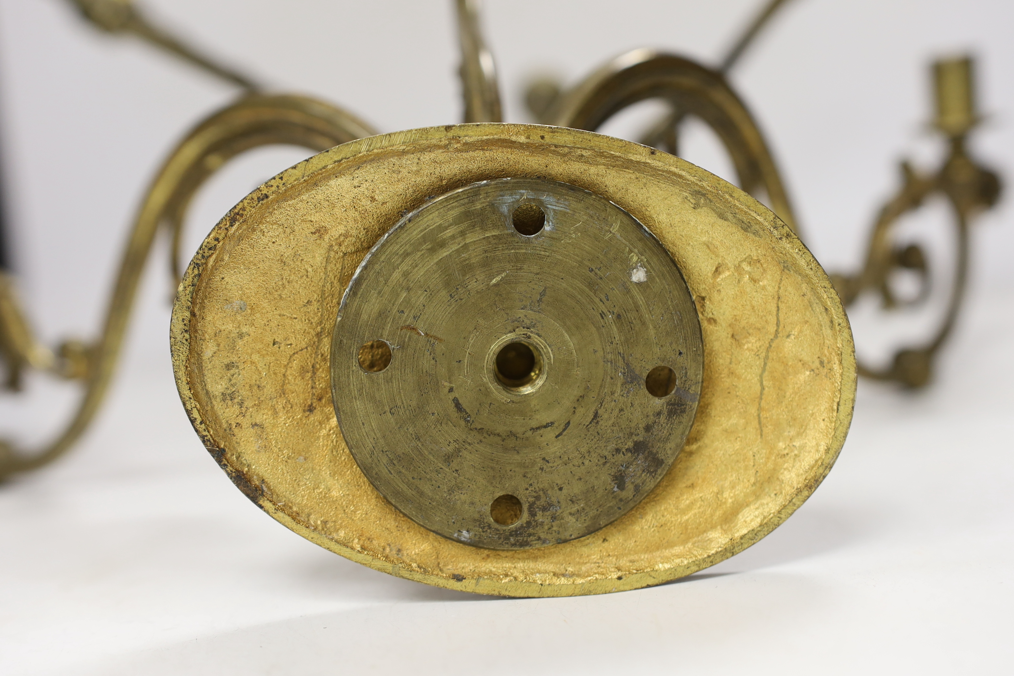 A pair of ornate brass three branch wall lights, 41cm wide